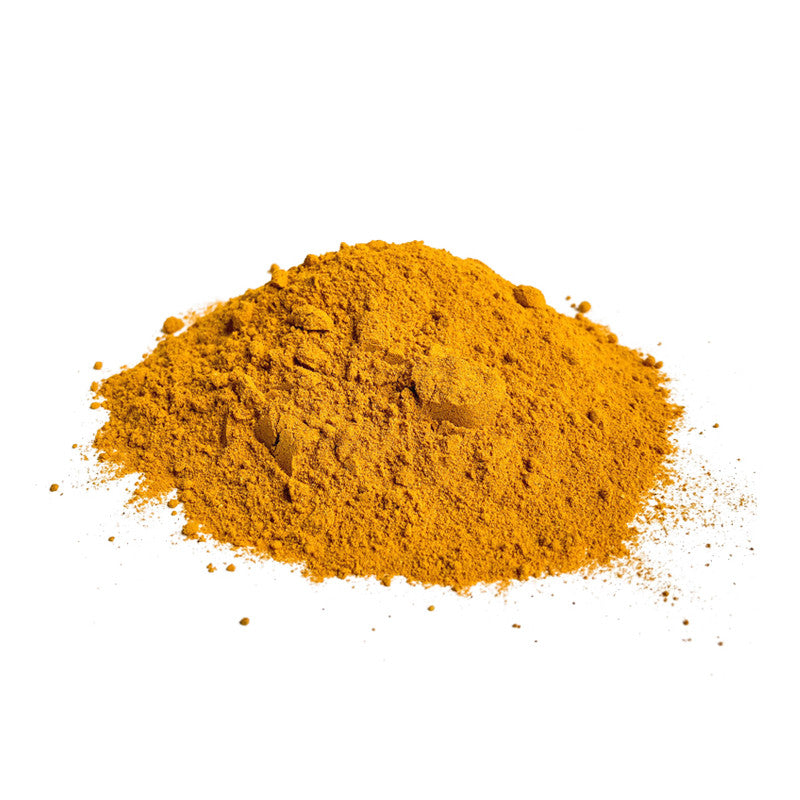 Pile of yellow turmeric powder on a white background